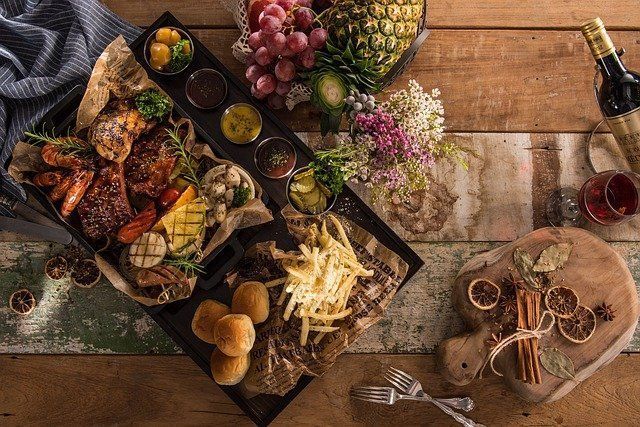Una mesa de madera cubierta con platos de comida y una botella de vino.