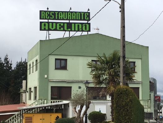 Un edificio verde con un cartel que dice restaurante avelino.