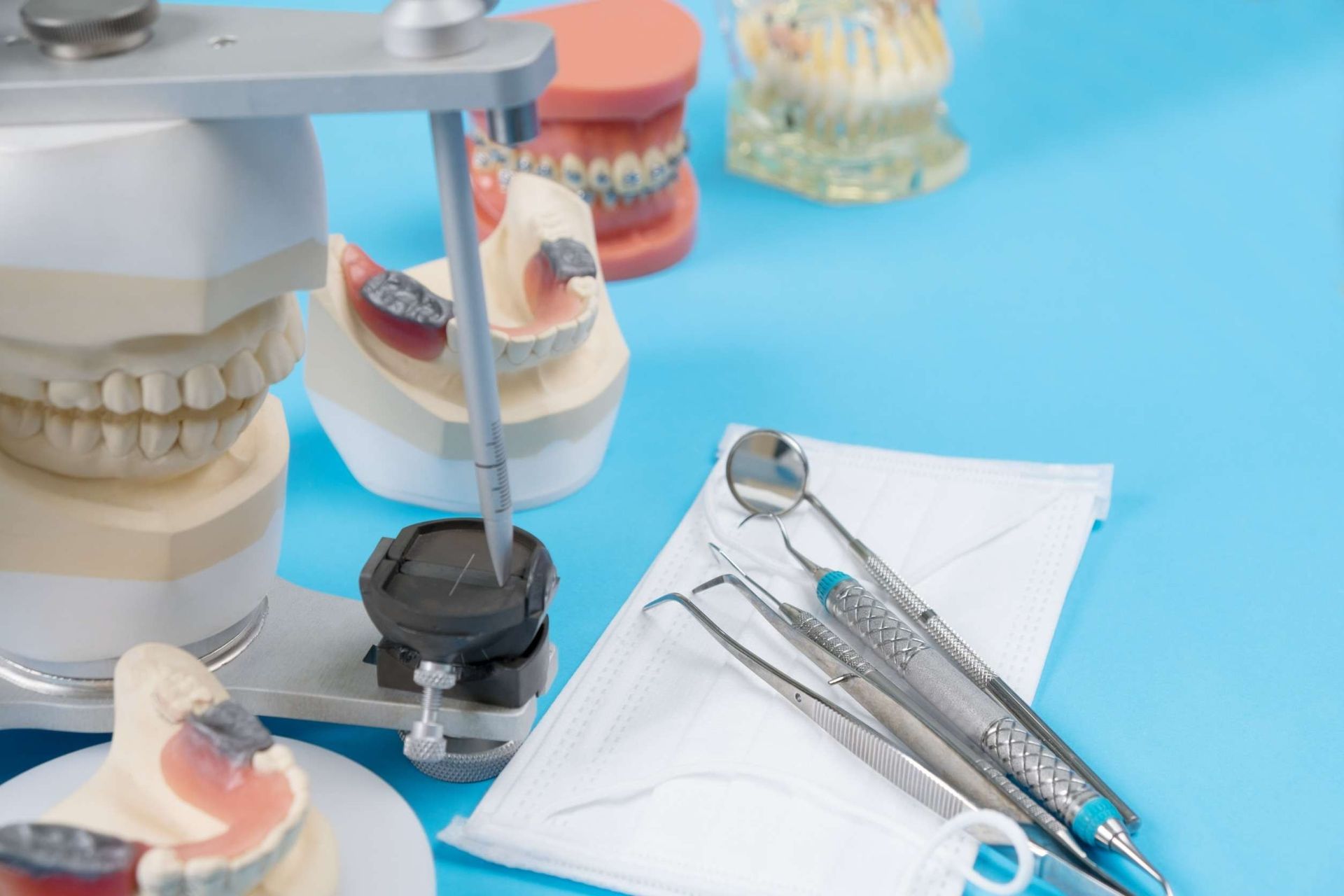 Una mesa azul cubierta con modelos dentales e instrumentos dentales.