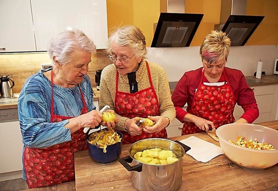 Ältere Damen schälen Kartoffeln