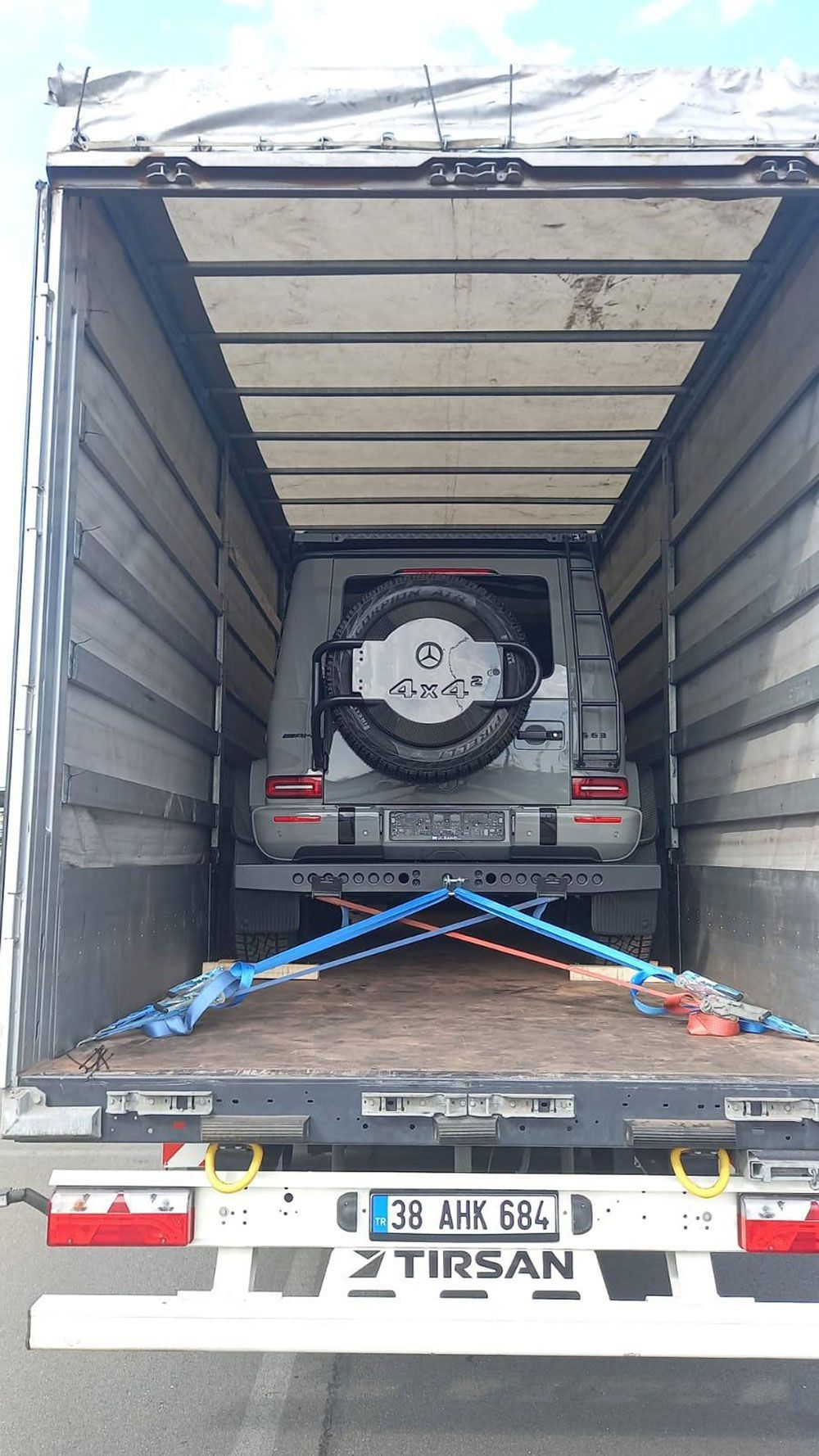 Auf der Ladefläche eines Lastwagens steht ein Auto.