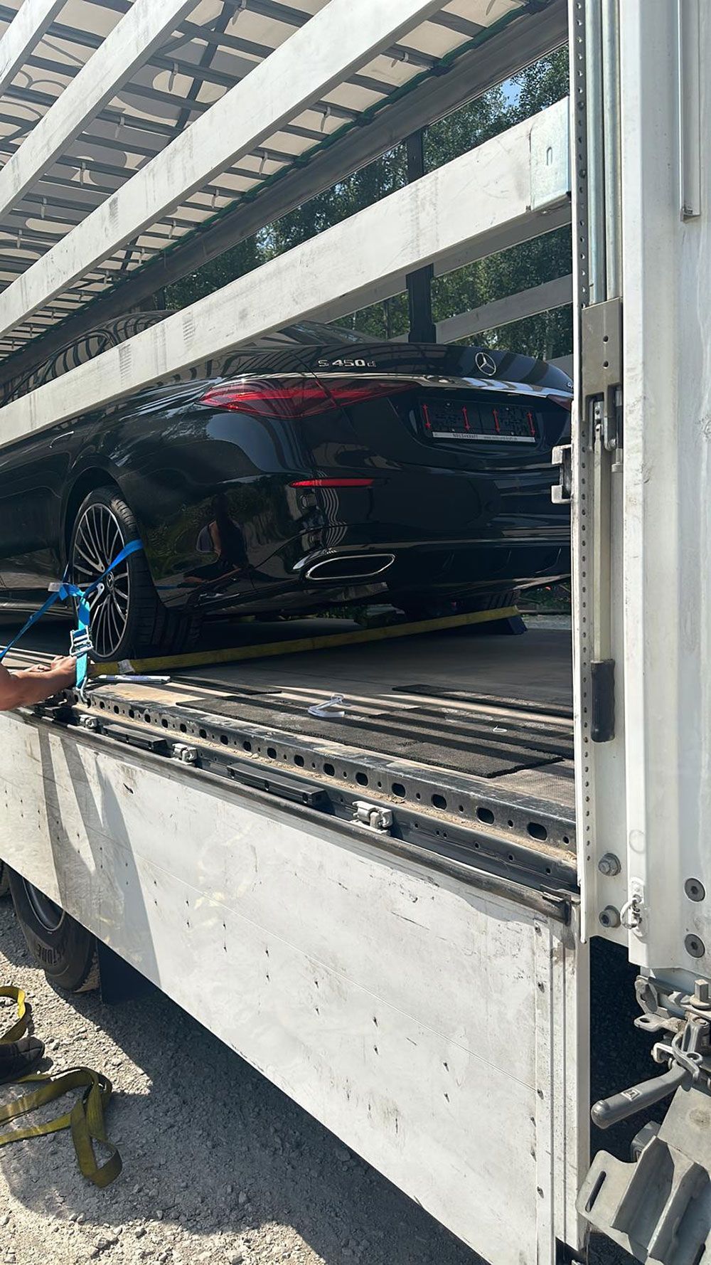 Ein Auto wird auf der Ladefläche eines LKW transportiert.