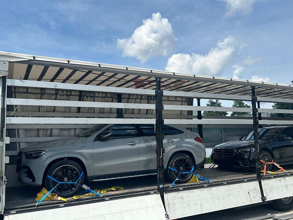 Auf der Ladefläche eines LKWs stehen zwei Autos.