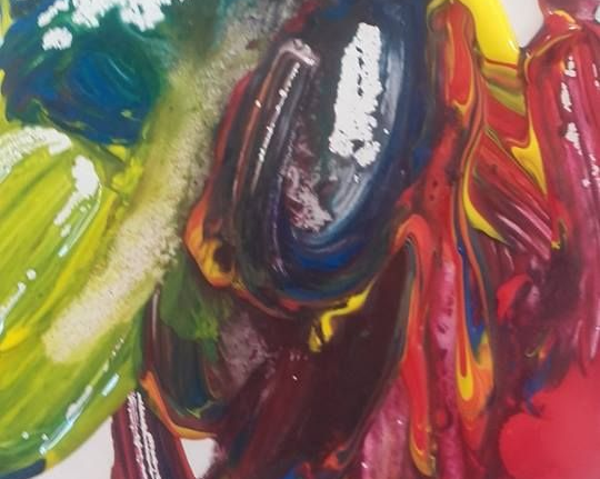 Peinture tourbillonnante et mélangée de bleu, rouge, jaune et vert, créant un motif abstrait et coloré.