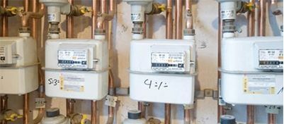 Una fila de medidores de gas colocados uno al lado del otro en una pared.