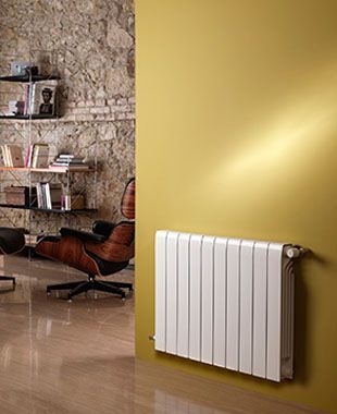 Una sala de estar con una silla y un radiador blanco en la pared.