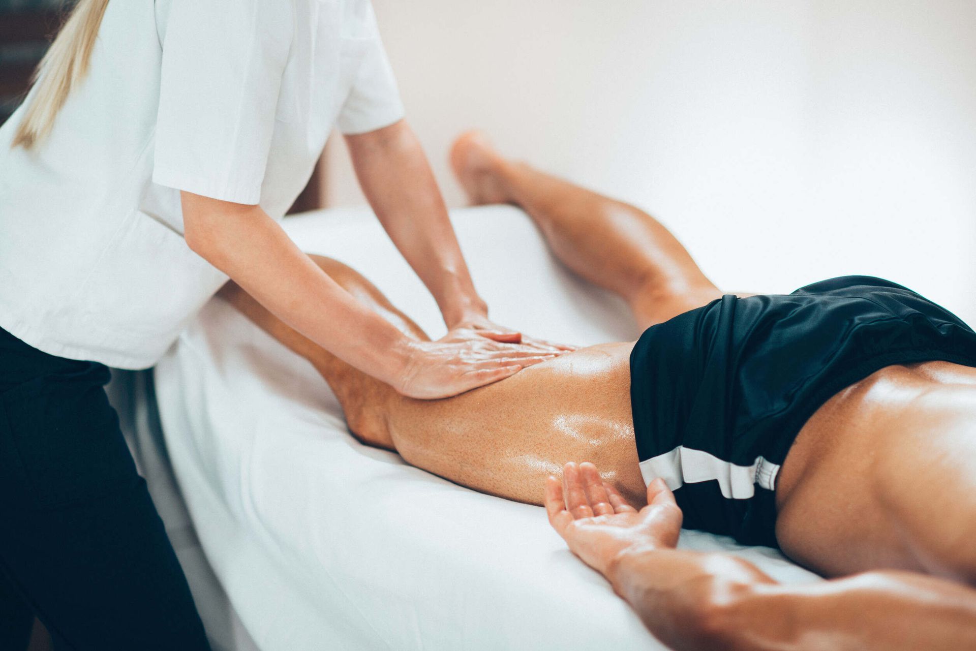 Un hombre está recibiendo un masaje en las piernas de un fisioterapeuta.