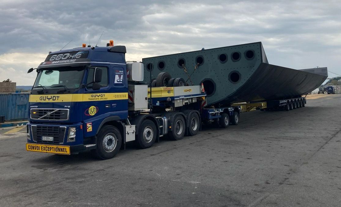 Un convoi exceptionnel de TRANSPORT GUYOT avec un semi-remorque bleu