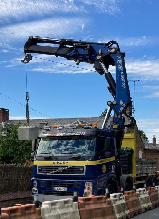 Un camion-grue bleu et jaune sur une route