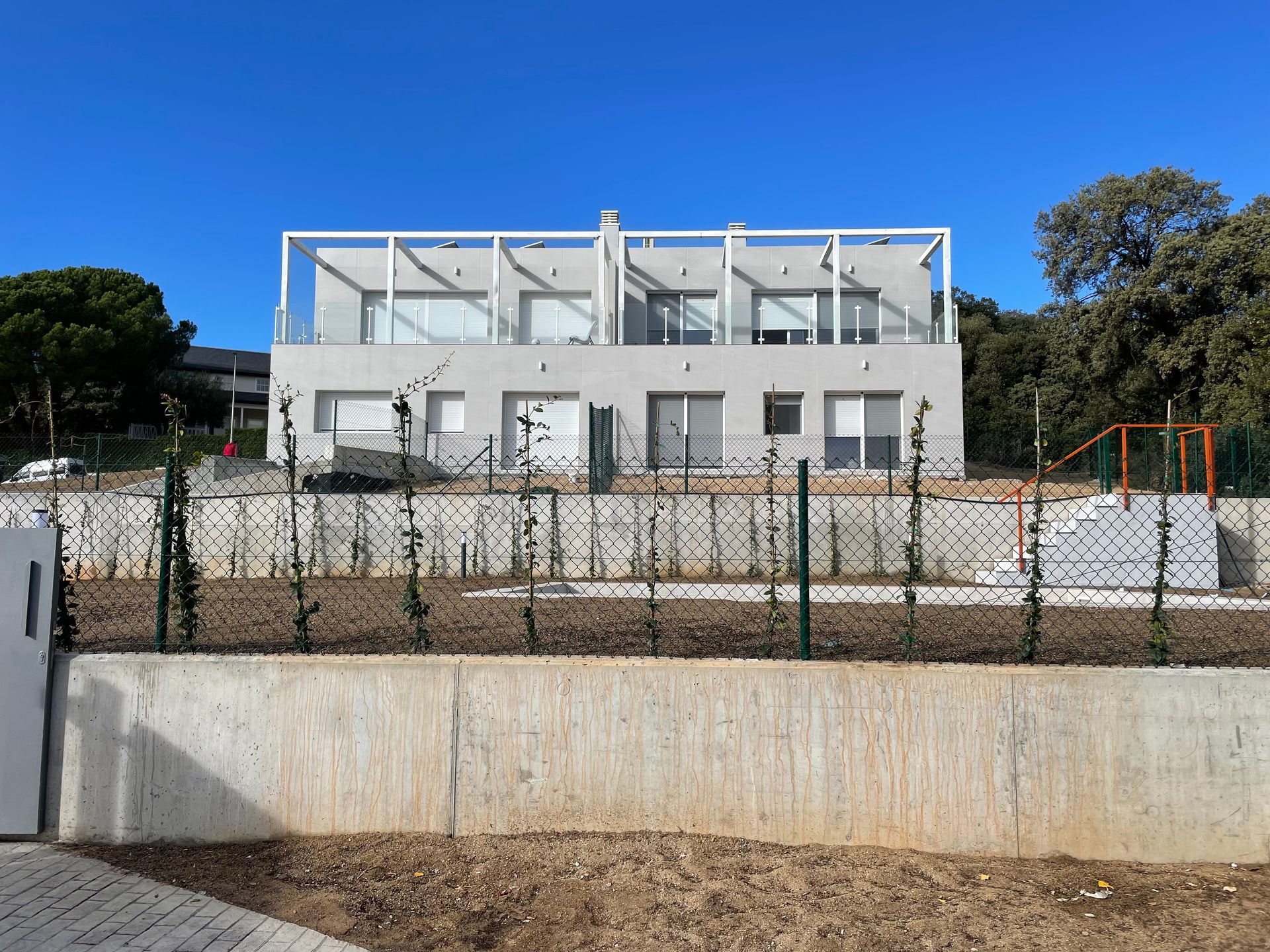 Una gran casa blanca con una valla delante.