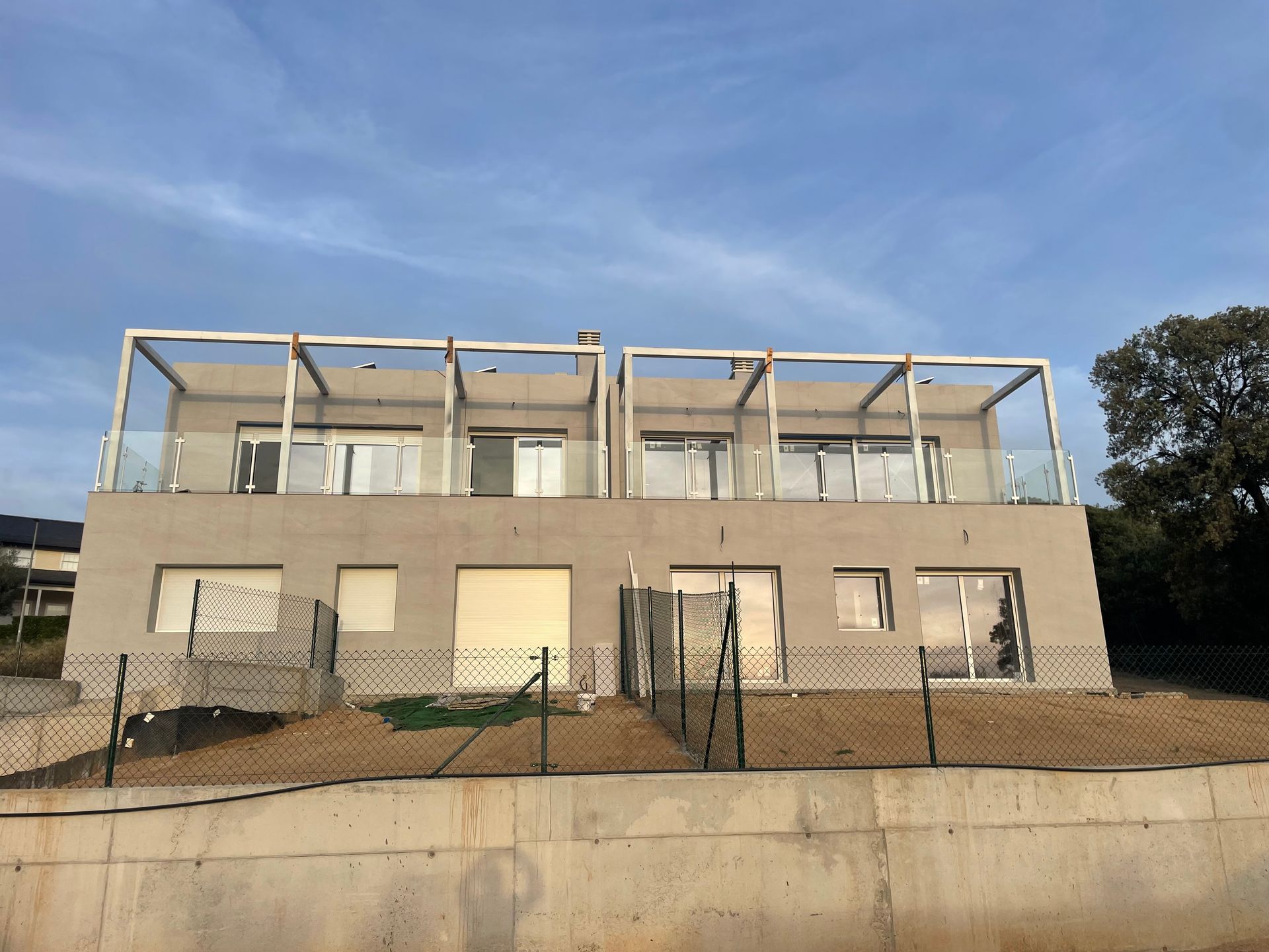 Un edificio grande con muchas ventanas y una valla alrededor.
