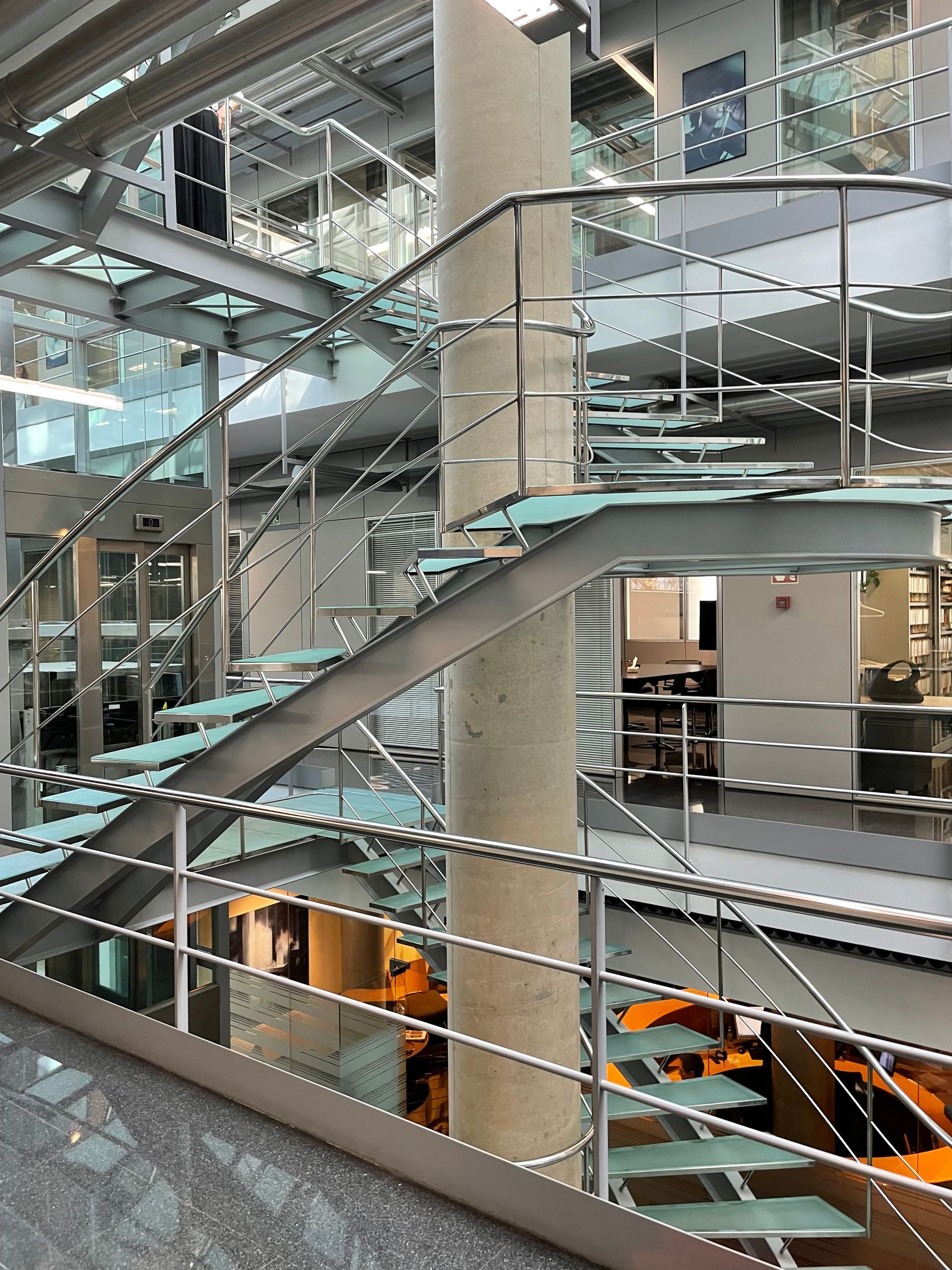 Una escalera en un edificio con barandilla de acero inoxidable.