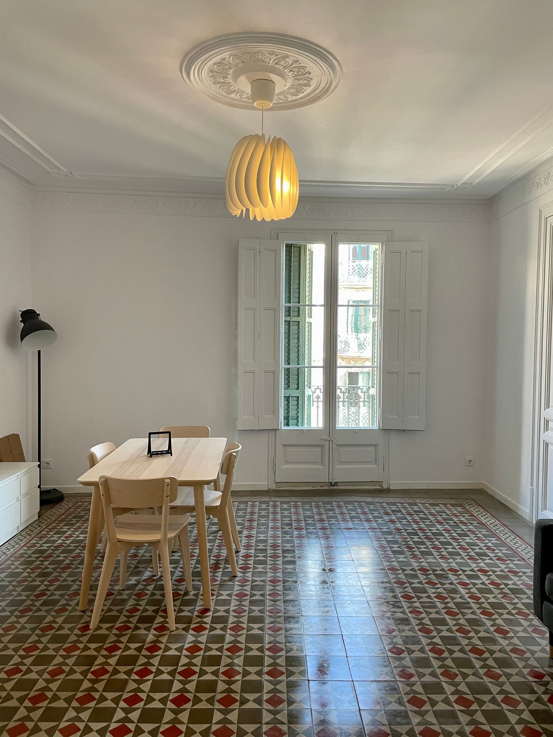 Una sala de estar con una mesa y sillas y una ventana.