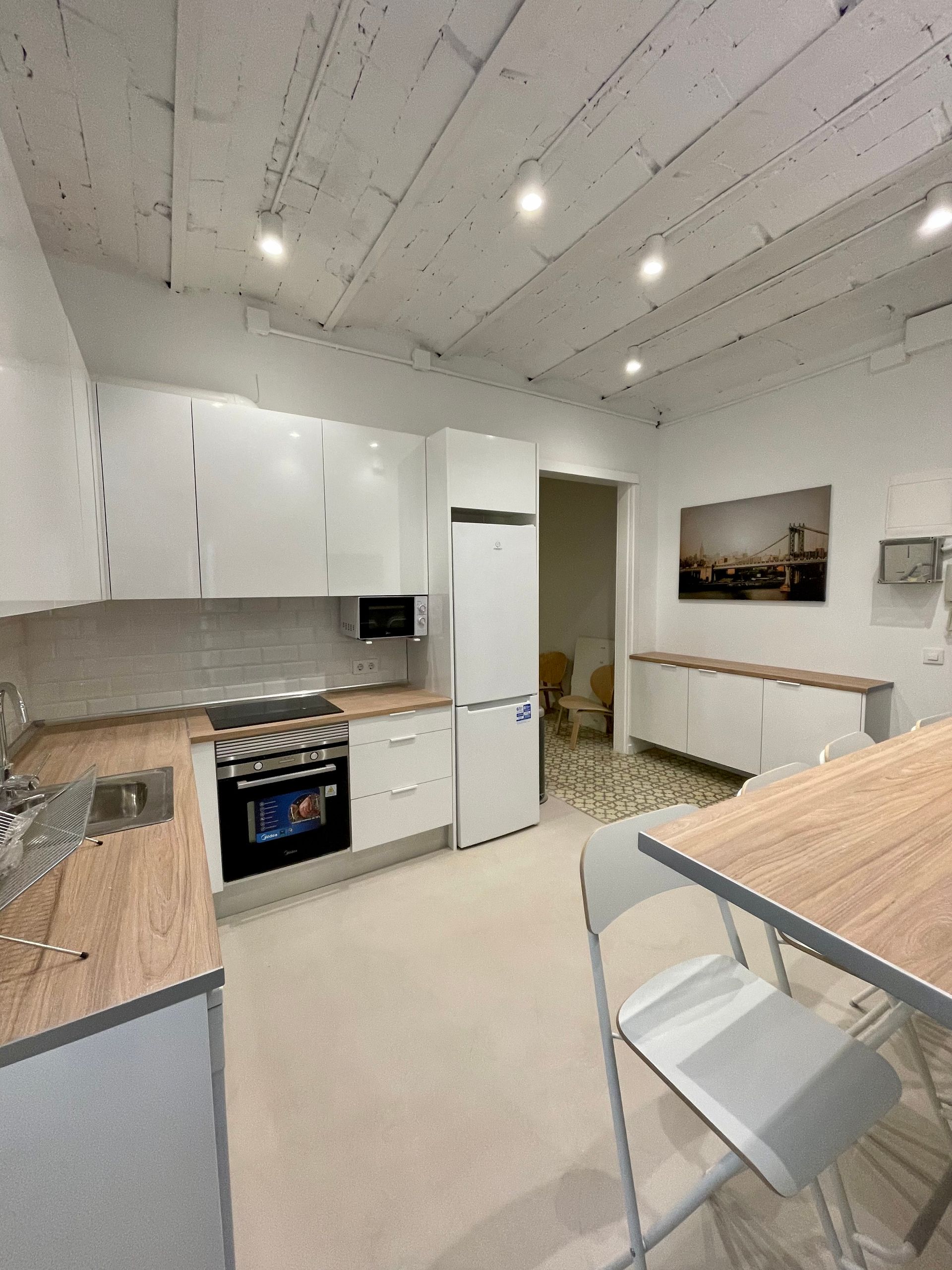 Una cocina con gabinetes blancos y encimeras de madera.