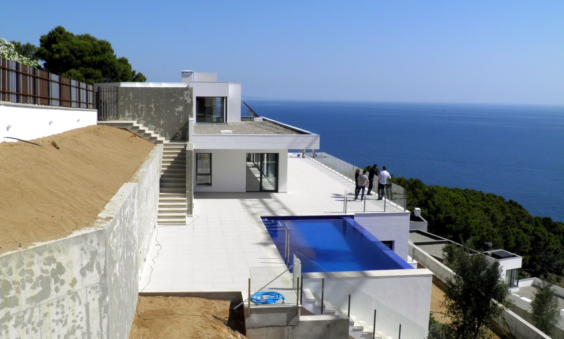 Una casa grande con piscina en la azotea con vista al mar.