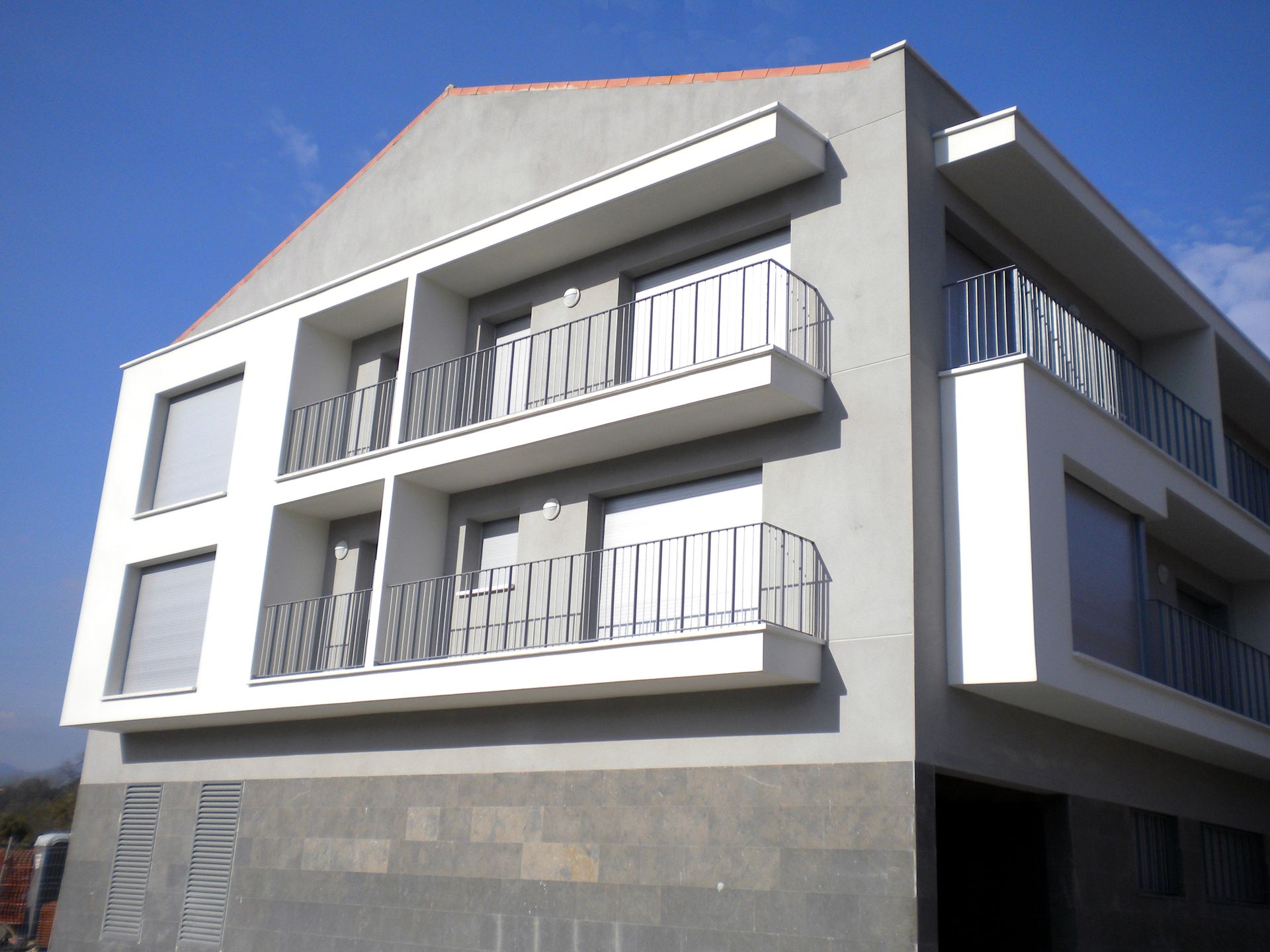 Un edificio con un balcón en el lateral.