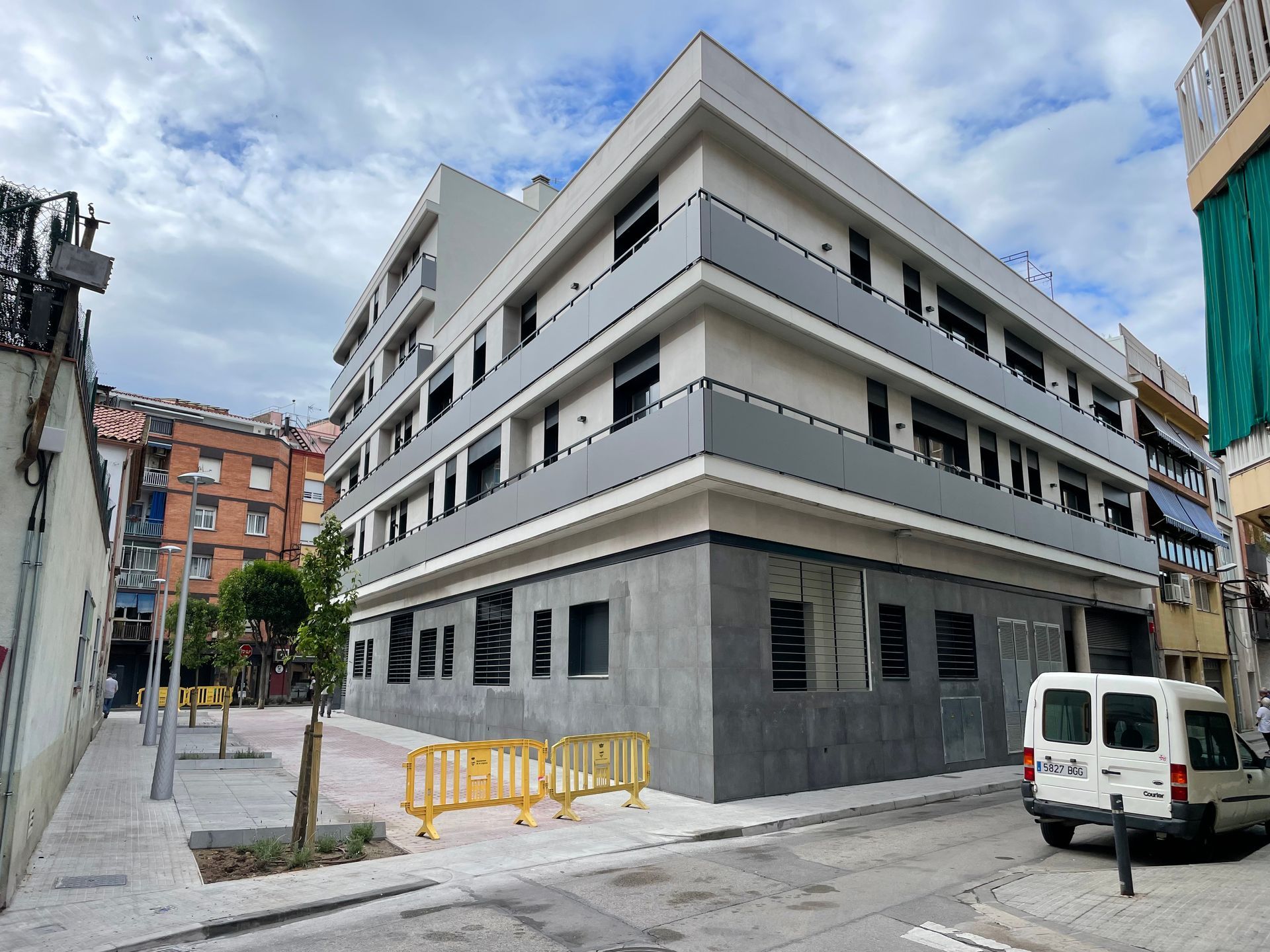Una camioneta blanca está estacionada frente a un gran edificio.