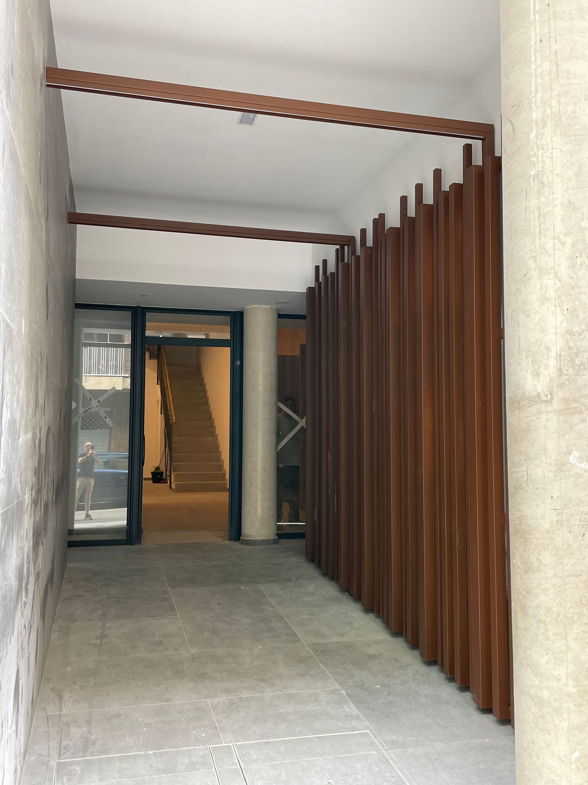 Un pasillo con una valla de madera y una escalera al fondo.