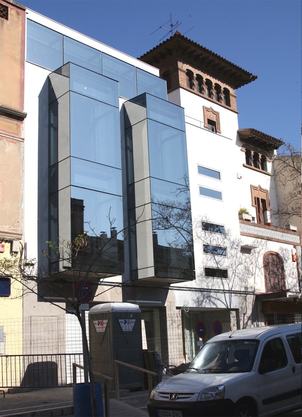 Una camioneta blanca está estacionada frente a un gran edificio.