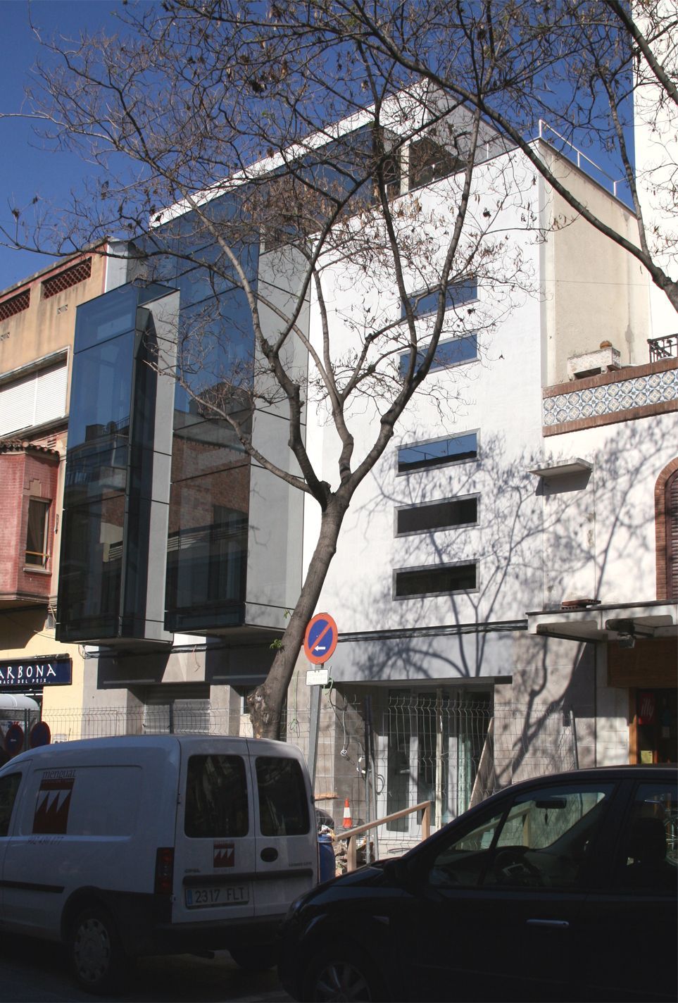 Una camioneta blanca está estacionada frente a un edificio