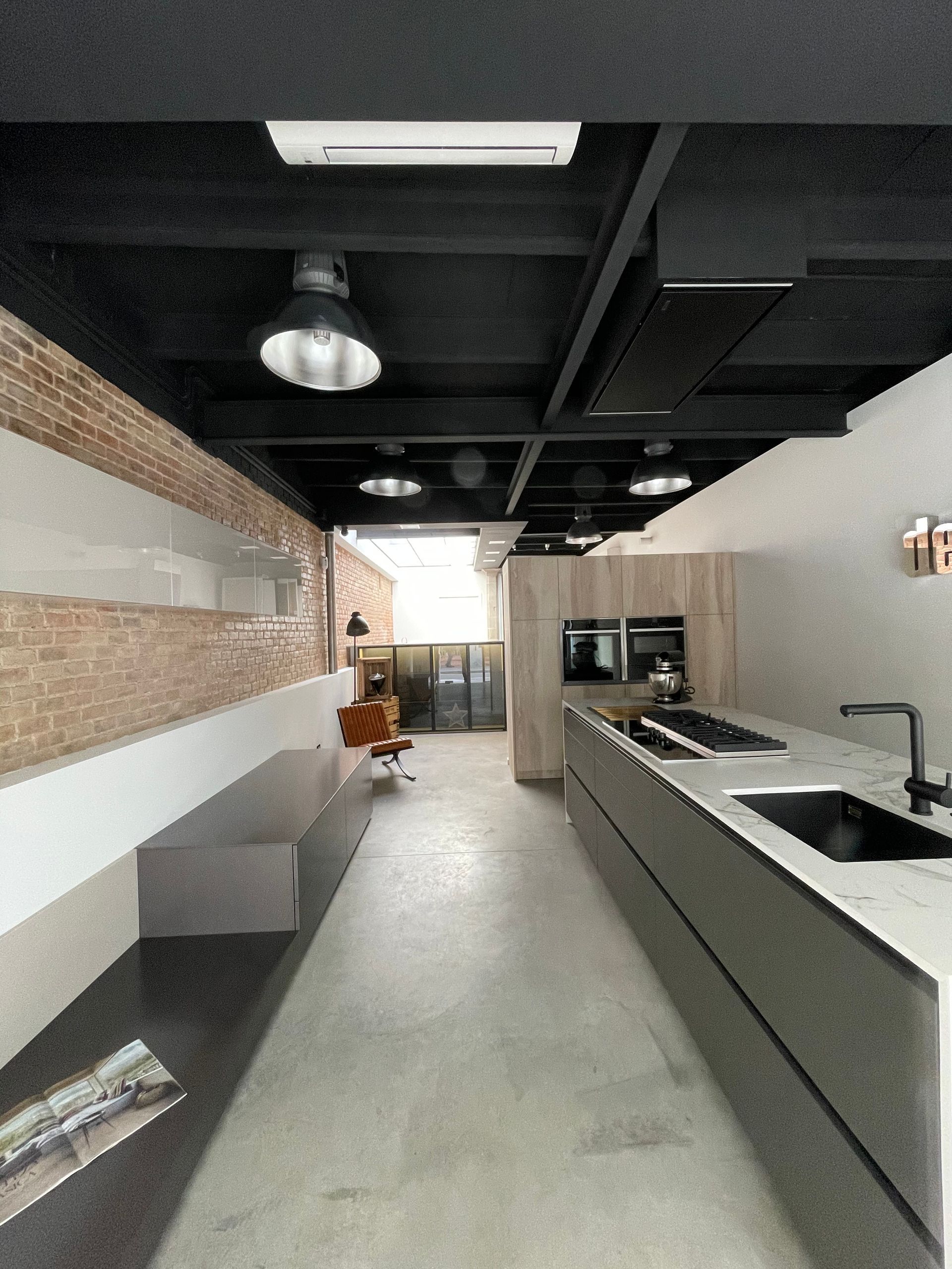 Una cocina con una encimera larga y un fregadero.