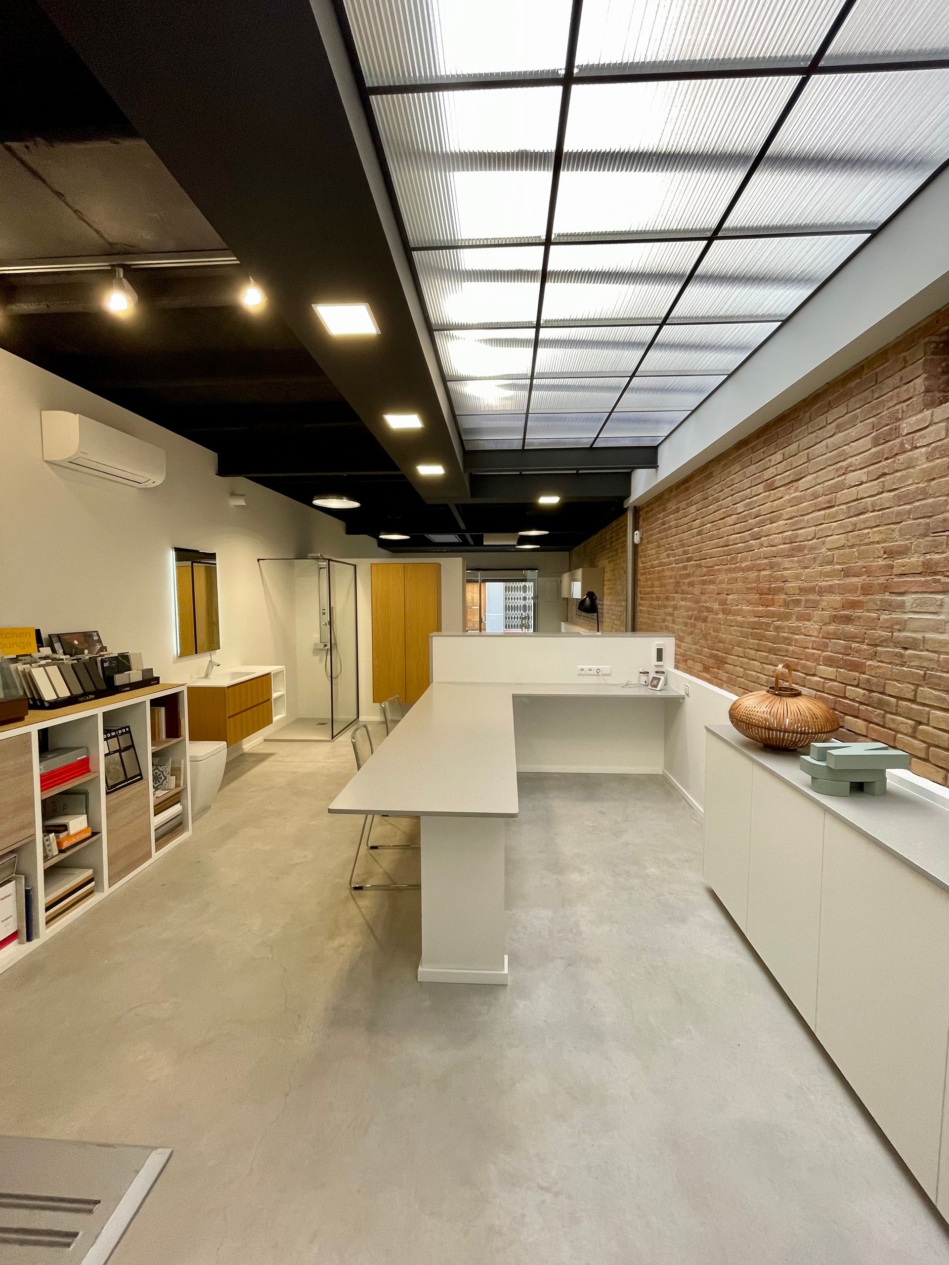 Una habitación grande con una pared de ladrillo y un techo de cristal.