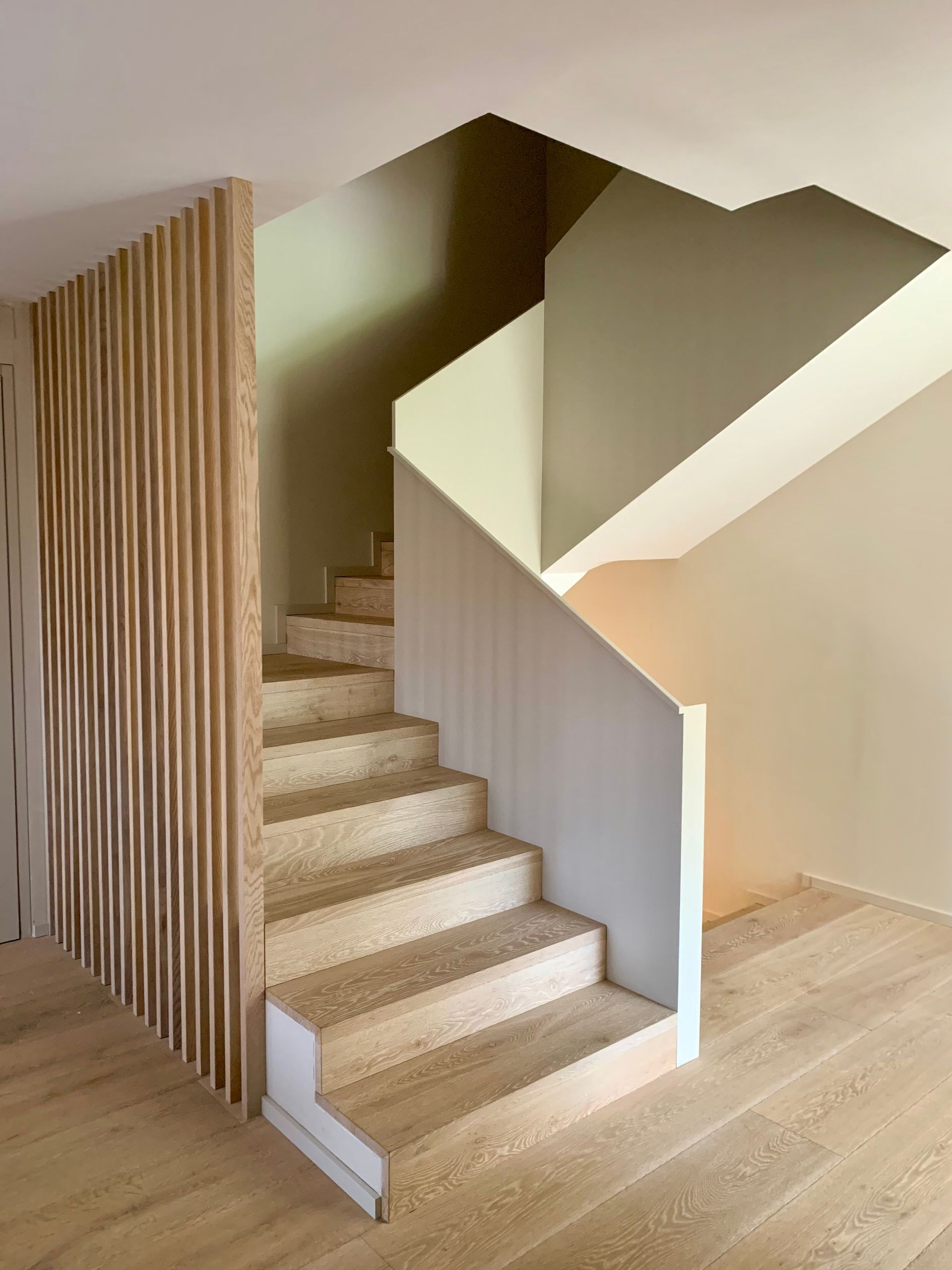 Una escalera con escalones de madera y barandilla blanca.