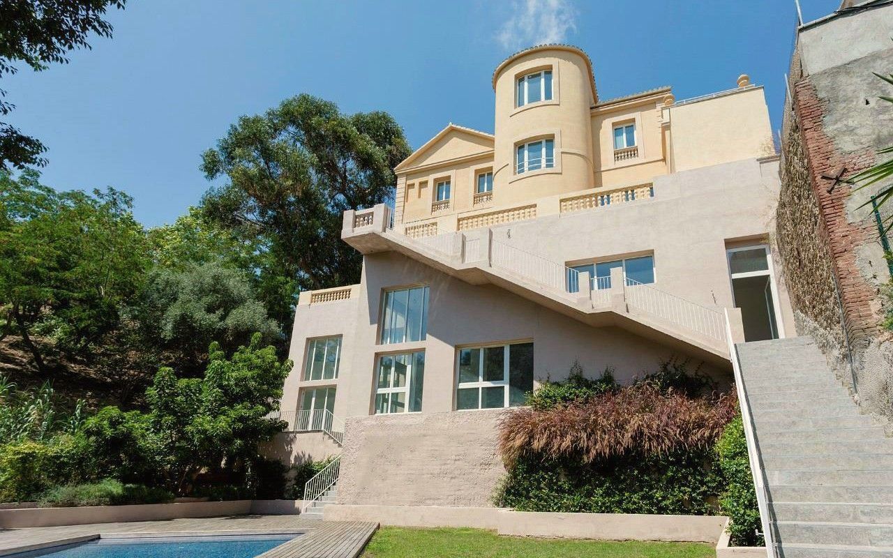 Una casa grande con piscina delante de ella.