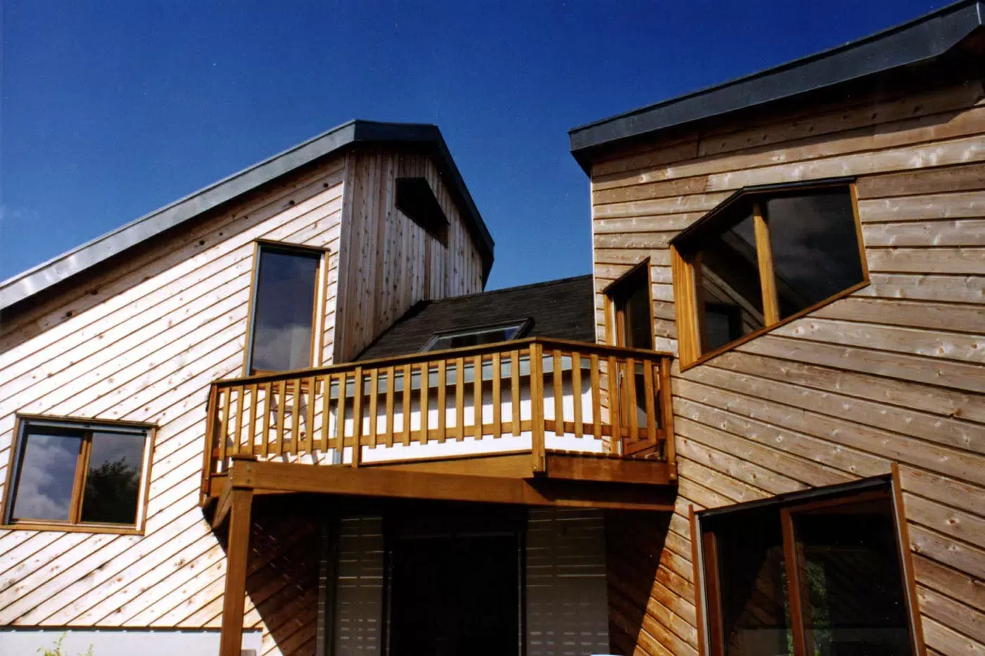 Maisons en bois avec un petit balcon se détachant sur un ciel bleu