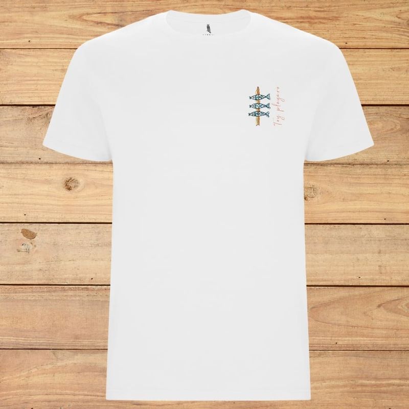 Camiseta blanca con un pequeño gráfico colorido en el pecho, extendida sobre un fondo de madera.