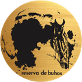Silueta de búho negro sobre un logotipo circular dorado con el texto “reserva de buhos” en la parte inferior.