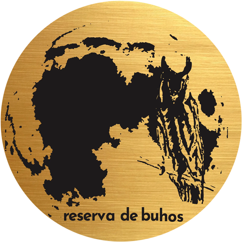 Silueta de búho negro sobre un logotipo circular dorado con el texto “reserva de buhos” en la parte inferior.