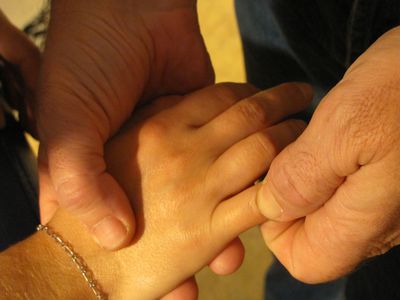 Une personne masse les doigts d'une autre personne.
