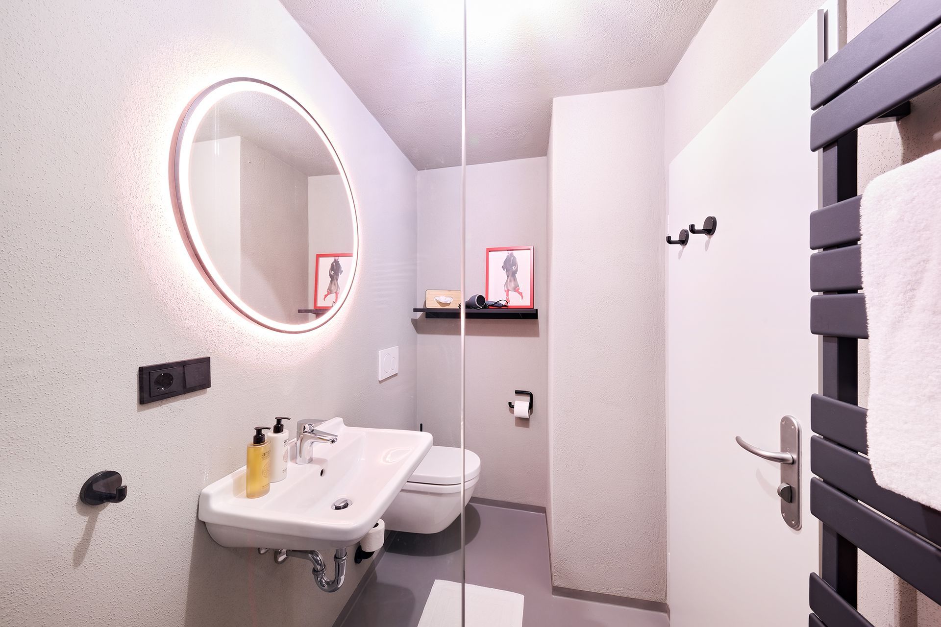 Ein Badezimmer mit Waschbecken, Toilette, Spiegel und Handtuchhalter.