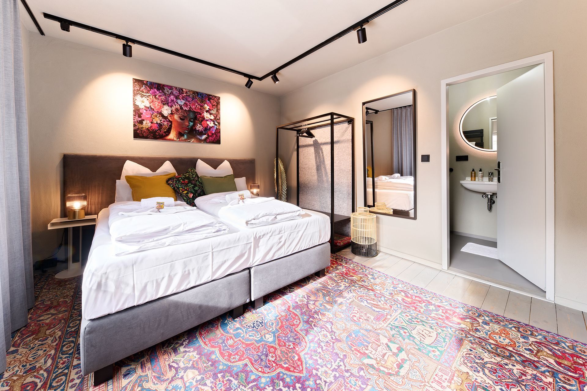 Ein Schlafzimmer mit zwei Betten, einem Teppich, einem Spiegel und einem Badezimmer.