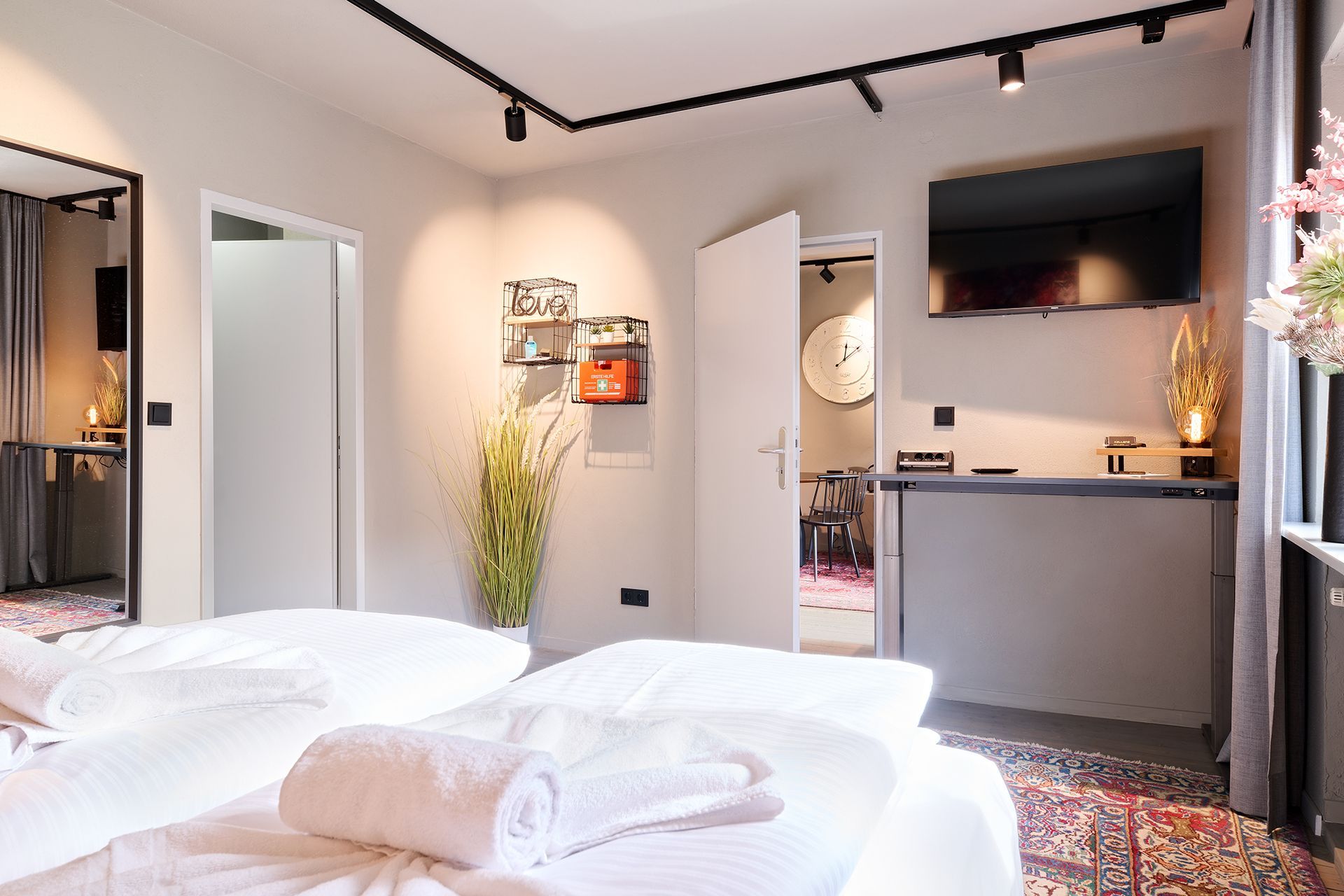 Ein Hotelzimmer mit zwei Betten und einem Flachbildfernseher.