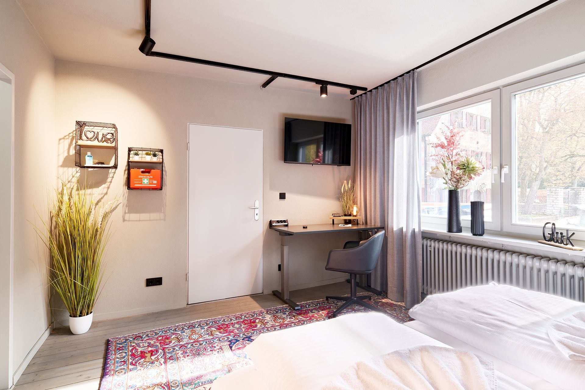 Ein Schlafzimmer mit Bett, Schreibtisch und Fernseher.