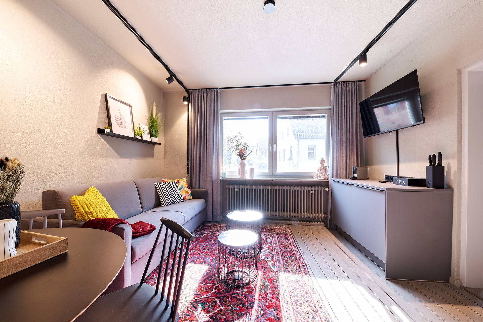 Ein Wohnzimmer mit einer Couch, einem Tisch und einem Fernseher