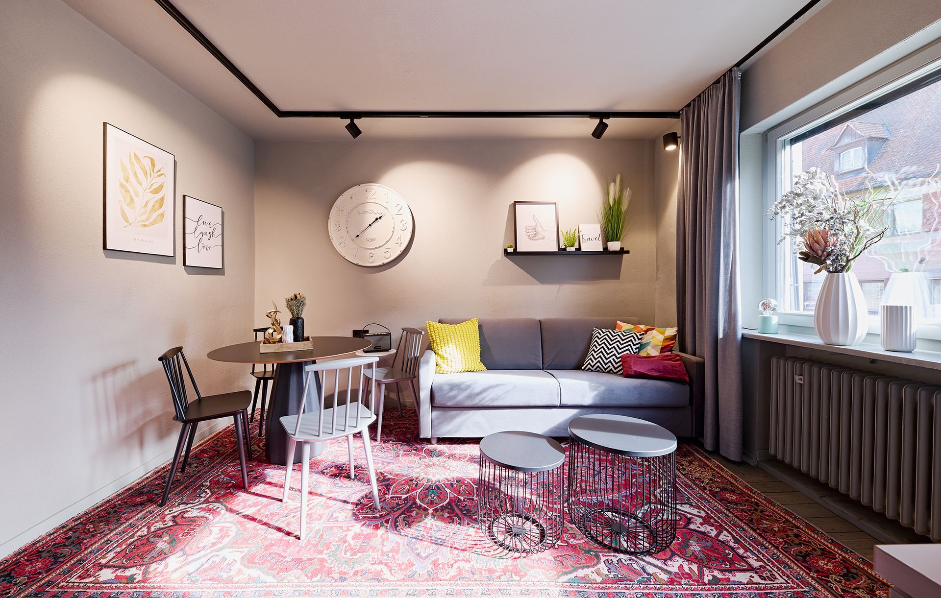 Ein Wohnzimmer mit Couch, Tisch, Stühlen und Teppich.
