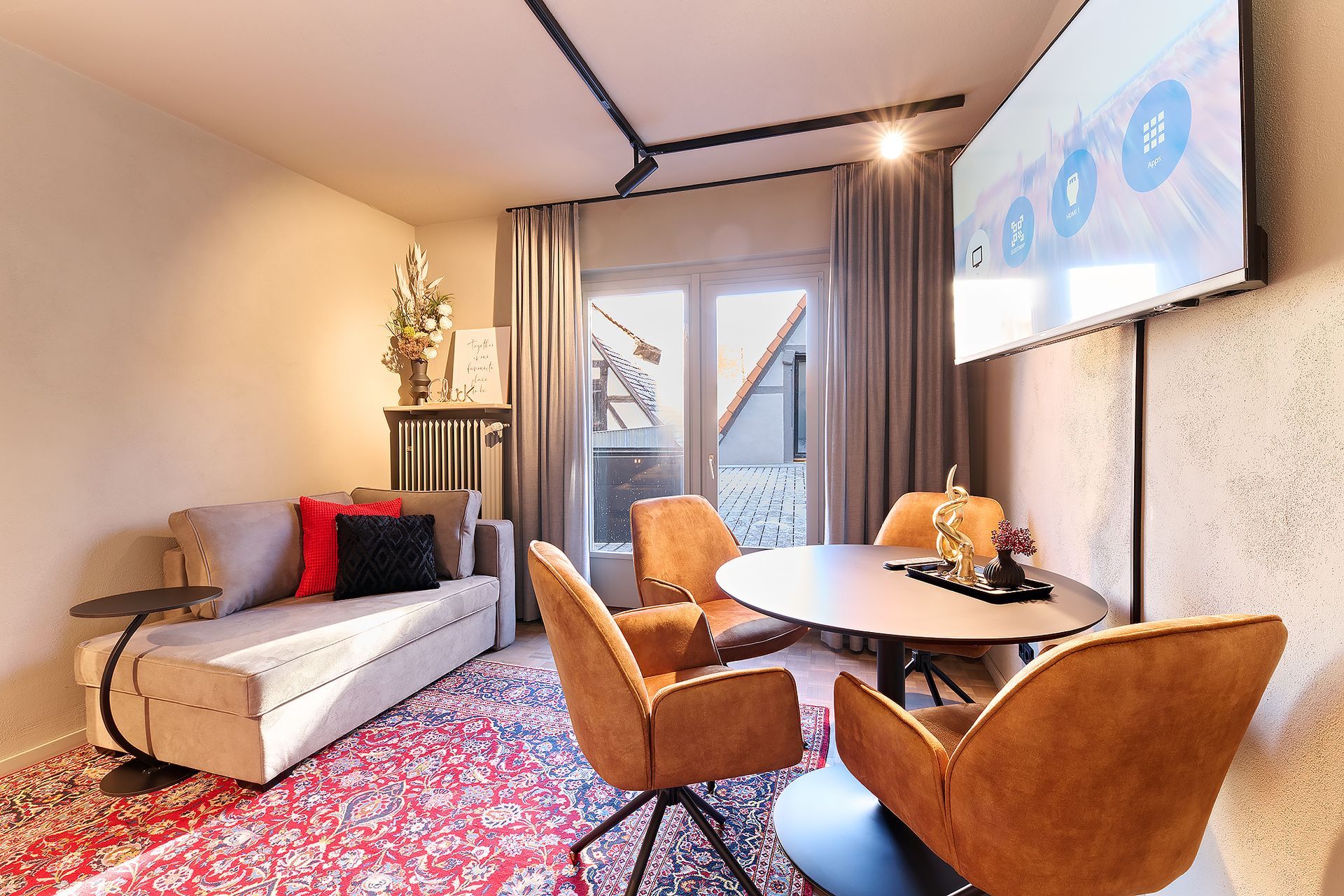 Ein Wohnzimmer mit Couch, Stühlen, Tisch und Fernseher.