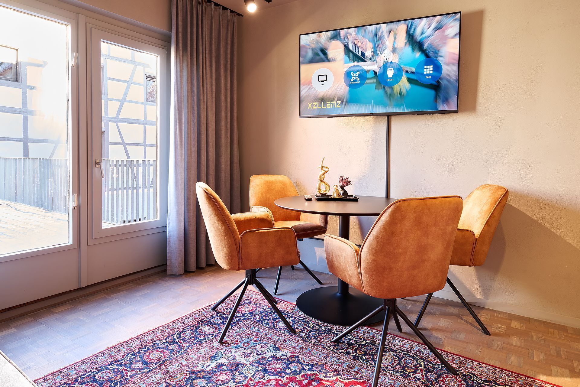 Ein Wohnzimmer mit Tisch und Stühlen und einem Flachbildfernseher.