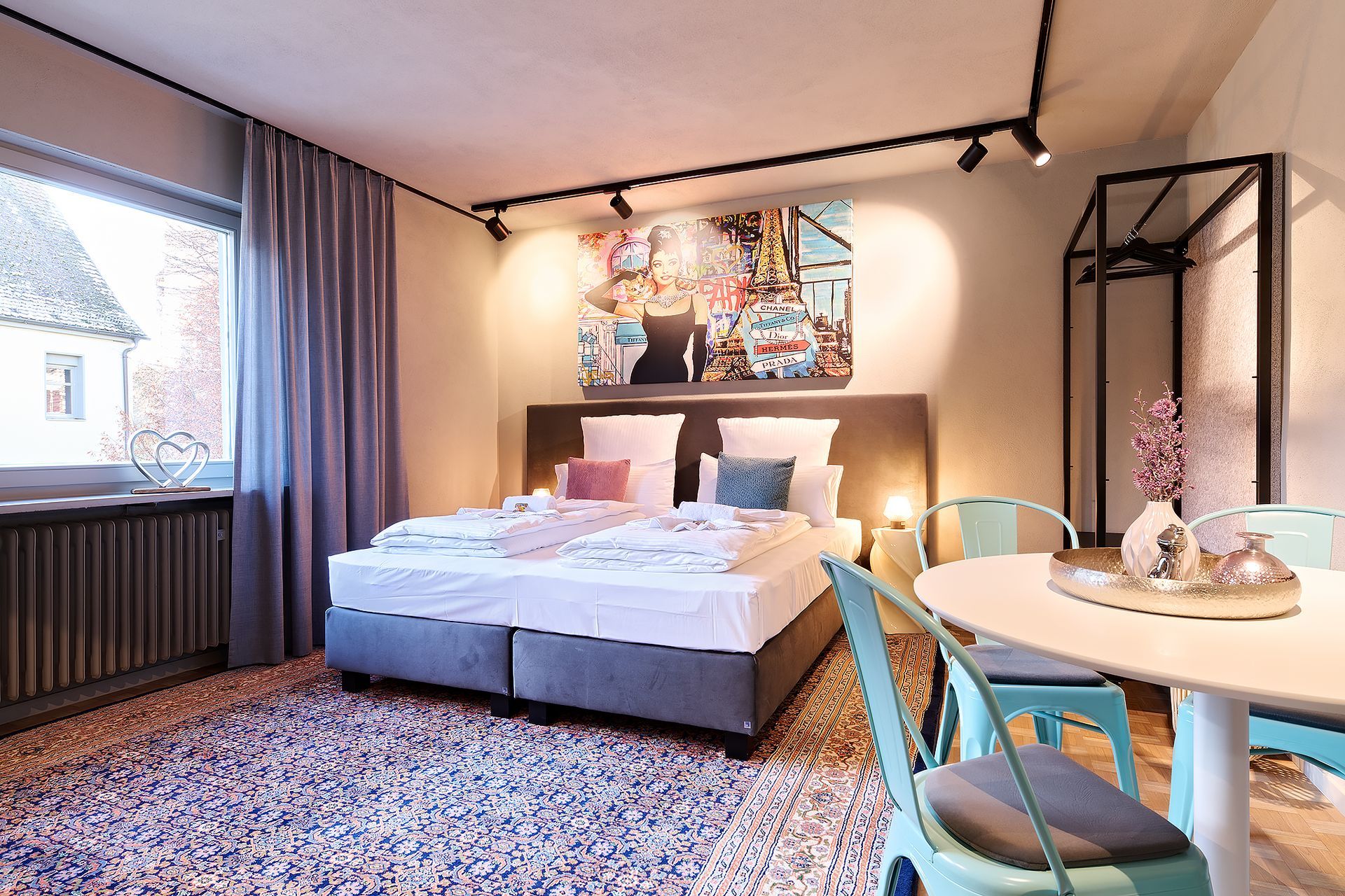 Ein Hotelzimmer mit Bett, Tisch und Stühlen.