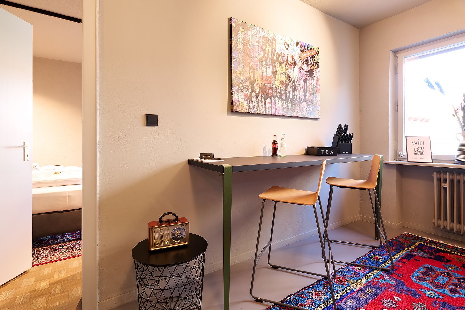 Ein Zimmer mit einem Schreibtisch und Stühlen und einem Gemälde an der Wand