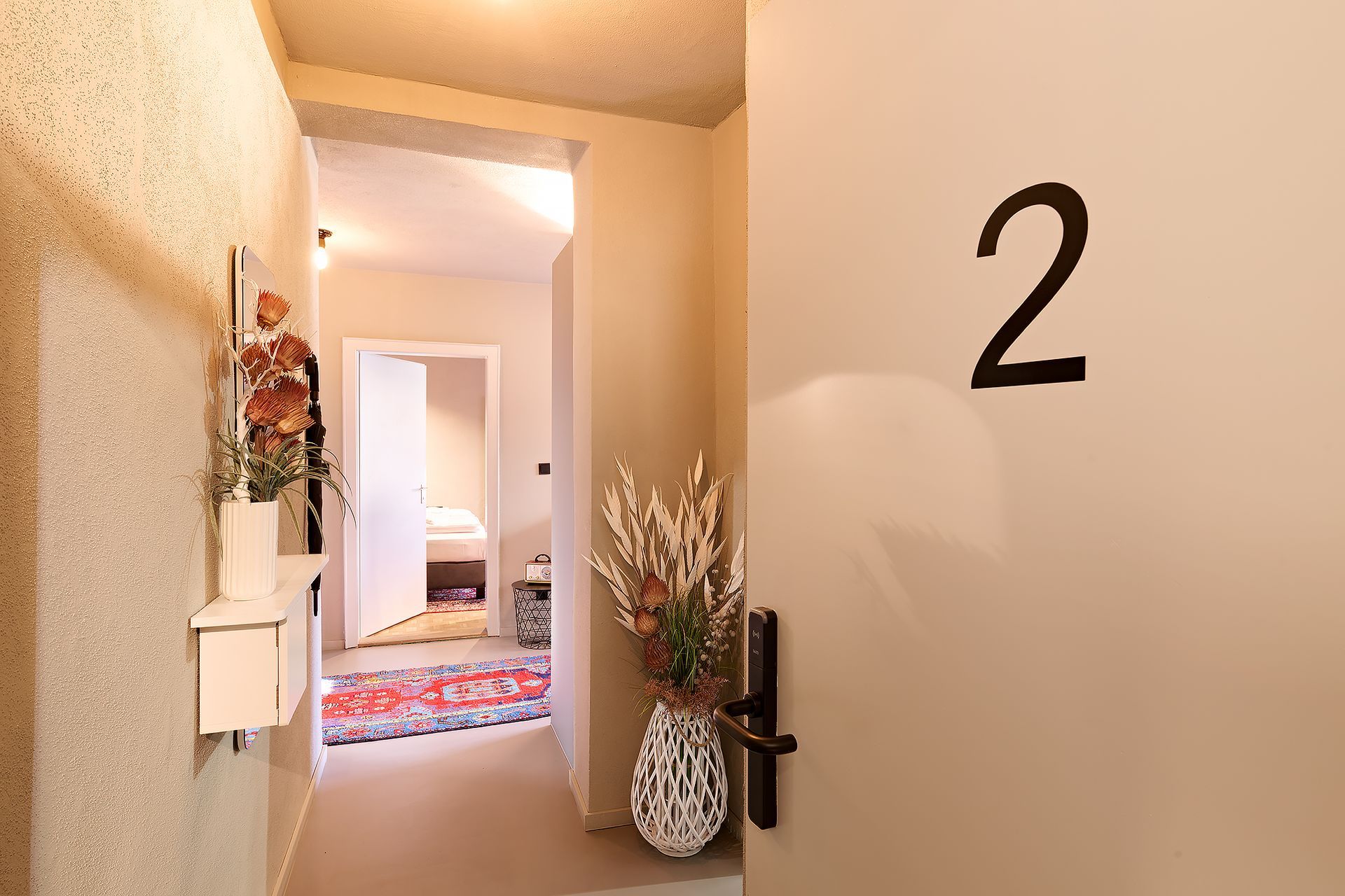 Ein Flur mit einer Blumenvase und der Zahl 2 an der Wand.
