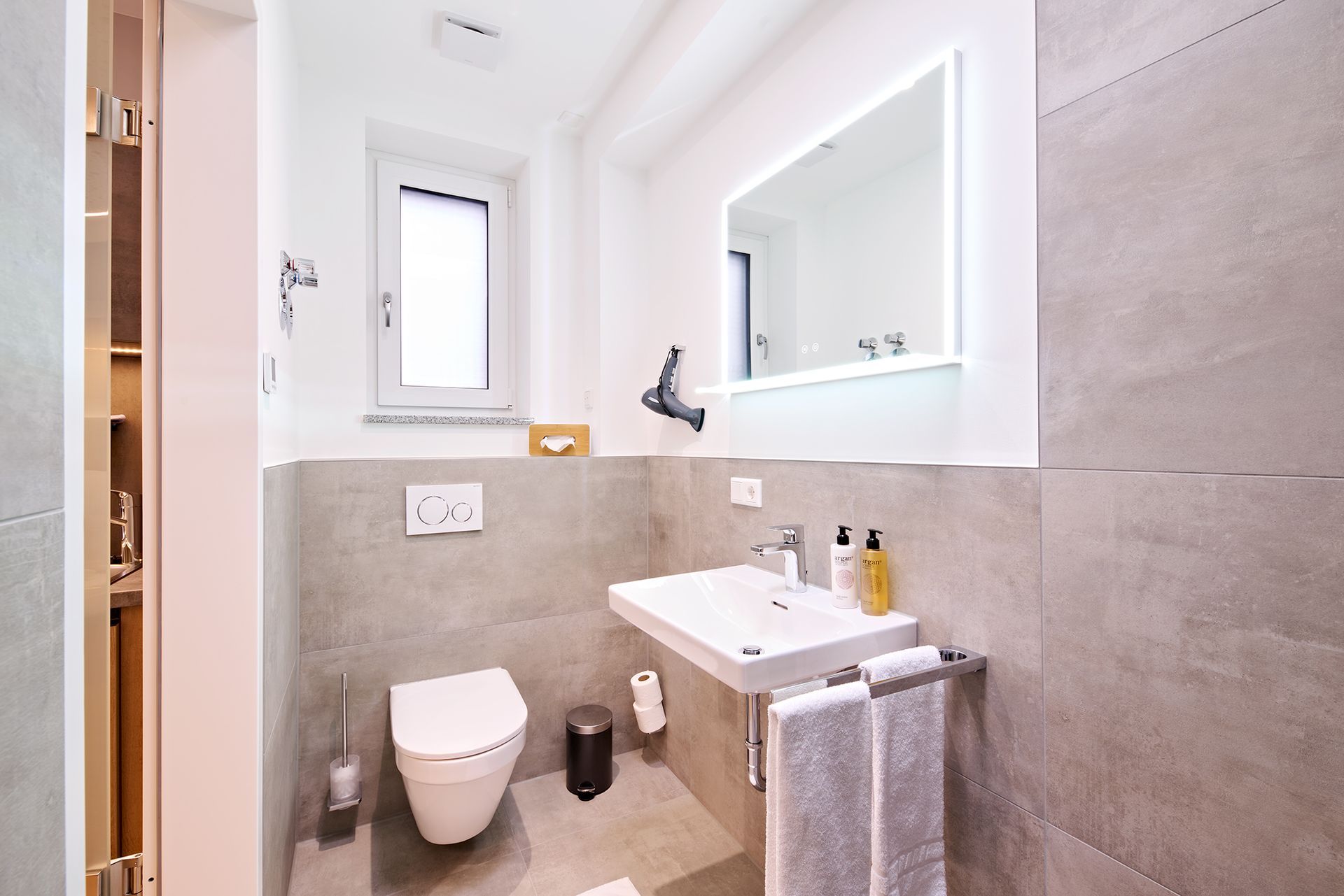 Ein Badezimmer mit Toilette, Waschbecken und Spiegel
