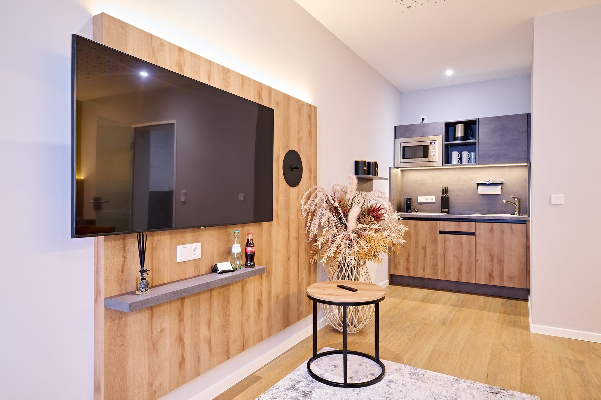 Ein Wohnzimmer mit einem großen, an der Wand montierten Flachbildfernseher.