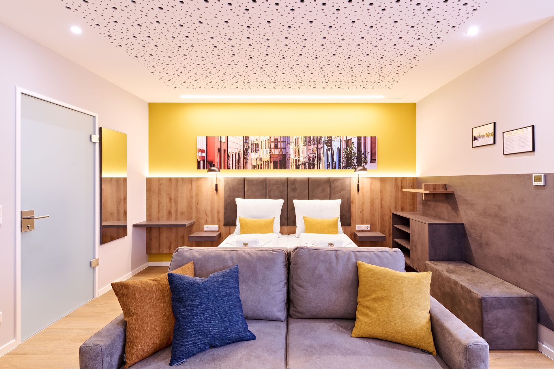 Ein Wohnzimmer mit einer Couch und einem Bett in einem Hotelzimmer.