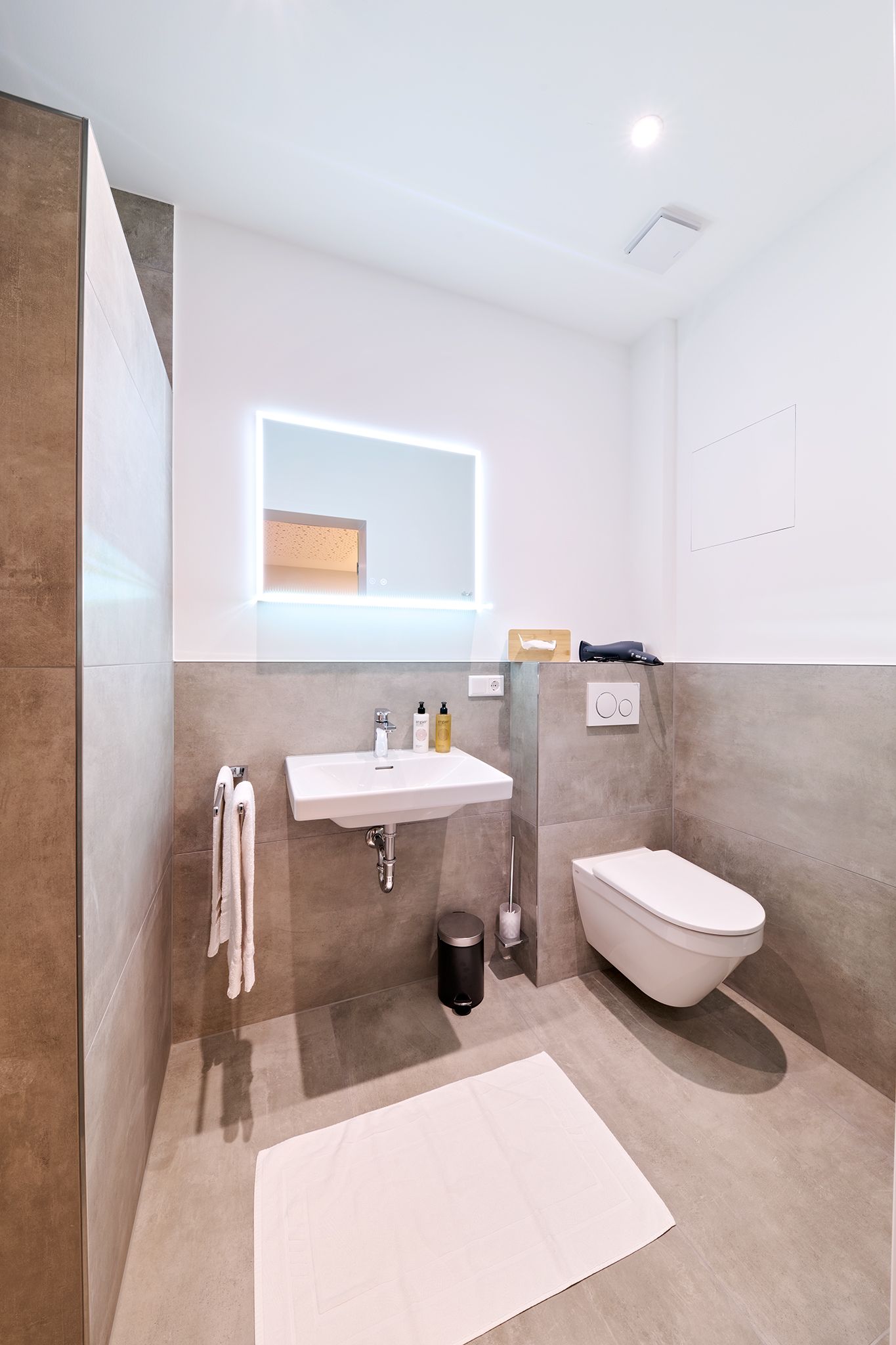 Ein Badezimmer mit Waschbecken, Toilette und Spiegel.