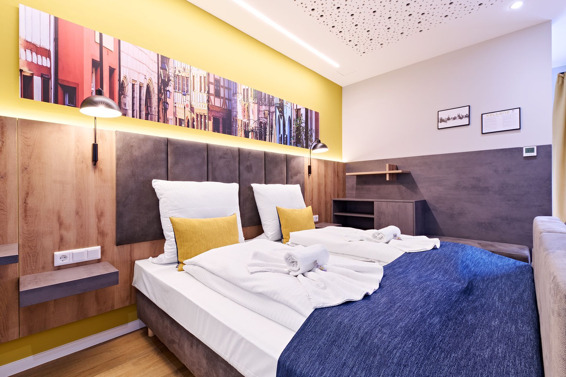 Ein Hotelzimmer mit zwei Betten und einem Gemälde an der Wand.