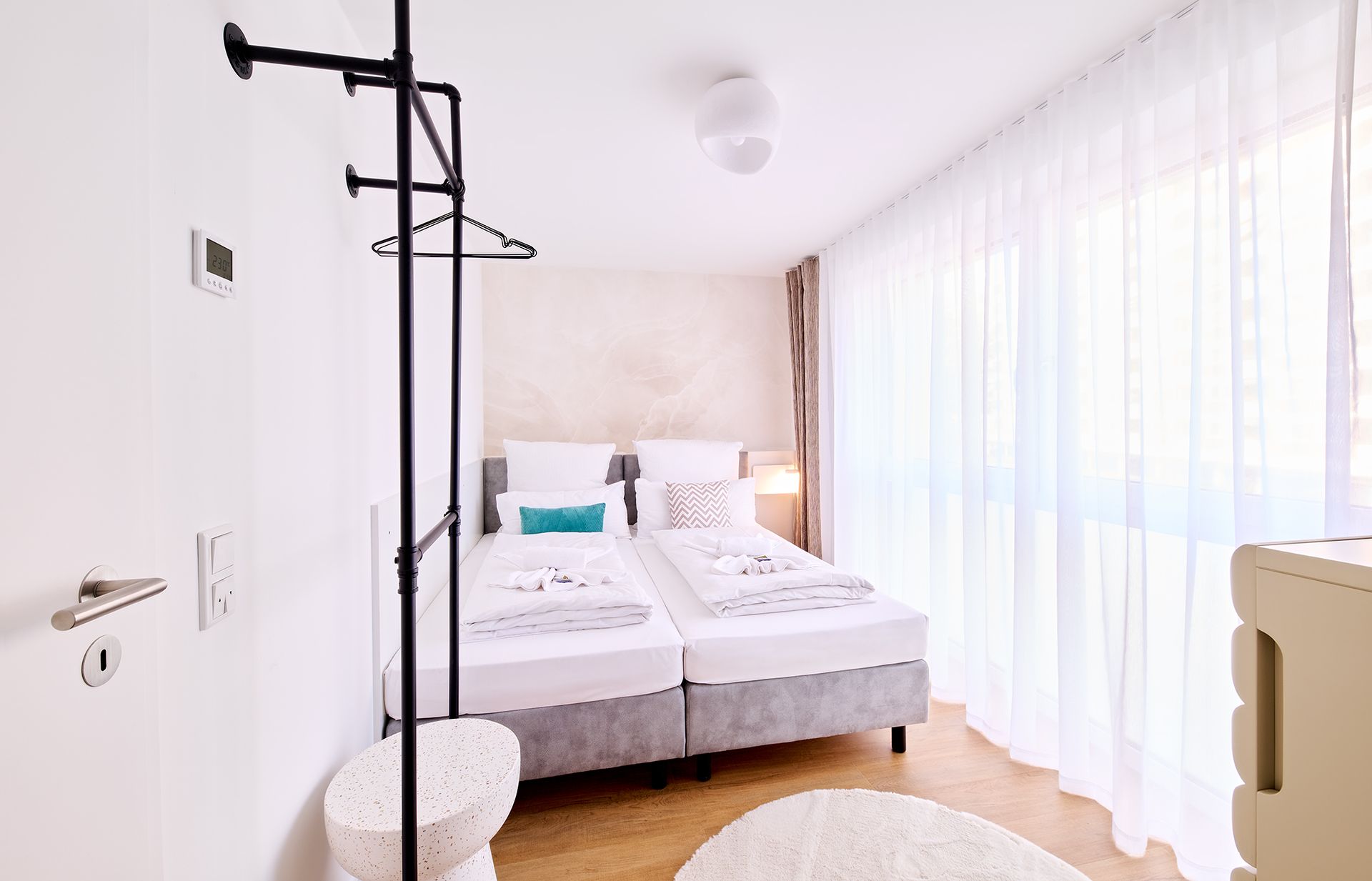 Ein Schlafzimmer mit zwei Betten, einer Kommode und einem Fenster.